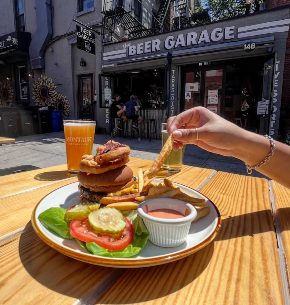 A plate of burgers and fries in front of Beer Garage