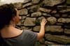 A tour guest touches an 18th century wall