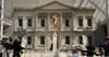 A gold statue stands at the center of the American Wing at the Metropolitan Museum of Art
