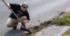New Orleans Sewage and Water boy cleaning out a storm drain with a shovel